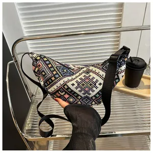 Detailed shot of ethnic woven crossbody bag with colorful geometric patterns and wide strap