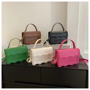 Detail shot of multi-color PU leather square bags with wavy texture and gold hardware