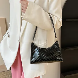 Black glossy patent leather underarm bag with V-shaped stitching and elegant shoulder strap