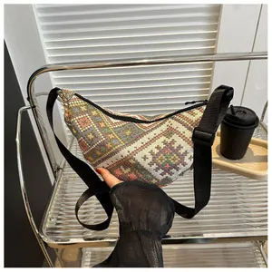 Detail of bohemian geometric woven texture and adjustable strap on a half-moon bag