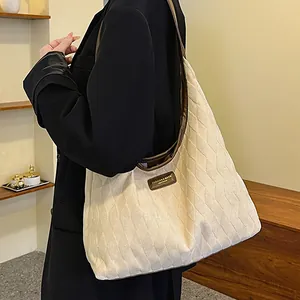 Grand sac cabas matelassé en toile crème avec bordures en cuir marron porté
