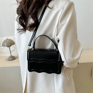 Minimalist black square handbag with wavy flap and adjustable strap for women