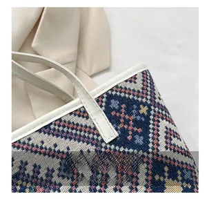 Détail du sac cabas tissé montrant les coutures précises et la texture du tissu
