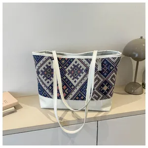 Détails du tissage ethnique géométrique et finitions en cuir blanc du grand sac cabas