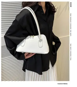 Gros plan d'un sac à main blanc avec fermetures dorées et détails en cuir texturé