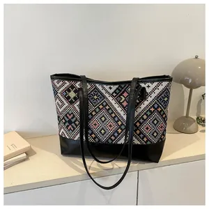 Détail du tissage géométrique ethnique et patchwork cuir sur un grand sac cabas épaule