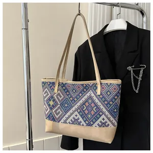 Détail du sac cabas bohème avec motifs tissés géométriques colorés et anses en cuir