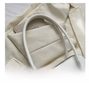 Gros plan sur la poignée épaisse en similicuir blanc d'un sac à main minimaliste chic