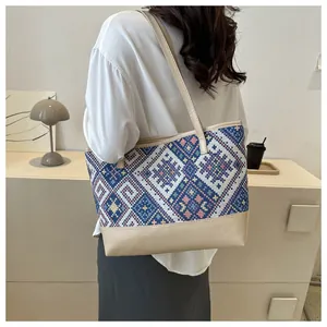 Détail du tissage ethnique géométrique et du cuir marron sur le sac cabas