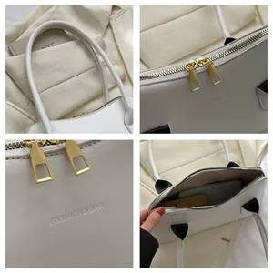 Vue détaillée d'un sac à main blanc avec fermetures éclair dorées et intérieur spacieux