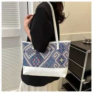 Détail du motif tissé ethnique et du sac cabas en cuir blanc avec patchwork