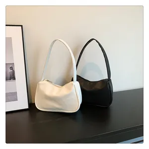 Details minimalistischer Lederschultertassen in Beige und Schwarz mit Narbenleder