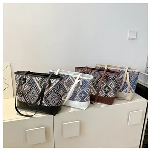 Sacs cabas tissés ethniques noir blanc marron et beige exposés sur un meuble blanc