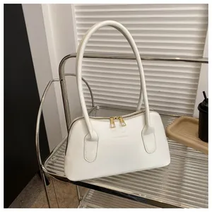 Détail du sac à bandoulière blanc avec double fermeture éclair dorée et logo tendance
