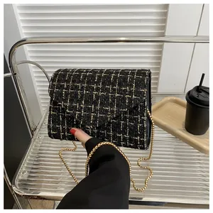 Detalle de bolso de tweed a cuadros negro y dorado con correa de cadena en estilo de vida