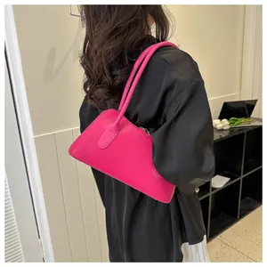 Détail du sac à épaule en cuir fuchsia avec zip doré et logo embossé tendance