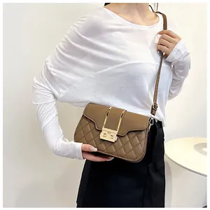 Detail view of brown quilted crossbody bag with gold metal buckle and adjustable strap