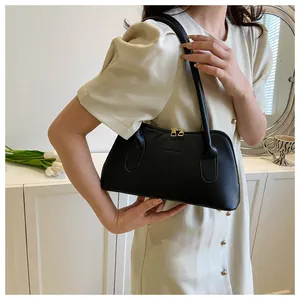 Gros plan du sac bandoulière en cuir mat noir avec double zip doré et texte en relief