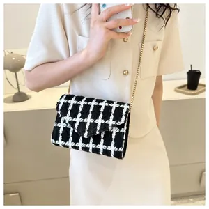 Detalle del bolso de tweed a cuadros con correa de cadena y atuendo elegante beige