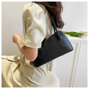 Détail d'un sac bandoulière noir minimaliste avec une texture en cuir mat raffiné