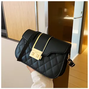 Detail of black quilted shoulder bag with golden buckle and sleek leather texture