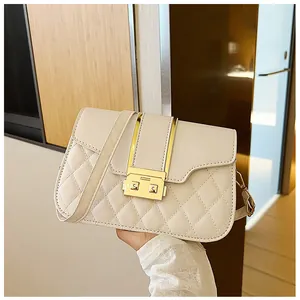 Close-up of cream quilted leather shoulder bag with elegant gold metal clasp hardware