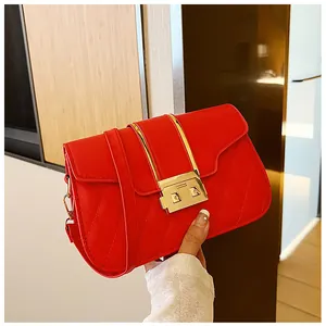 Detailed close-up of red quilted crossbody bag with gold metallic bars and buckle
