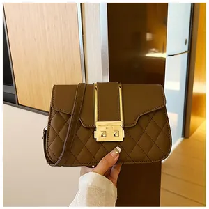 Close-up of brown quilted leather shoulder bag featuring a gold metal buckle closure