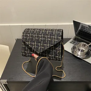 Bolso bandolera de tweed negro con cadena dorada y textura metálica para mujer chic