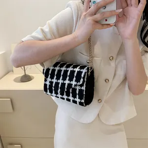 Elegante bolso bandolera de tweed blanco y negro con cadena dorada en modelo mujer