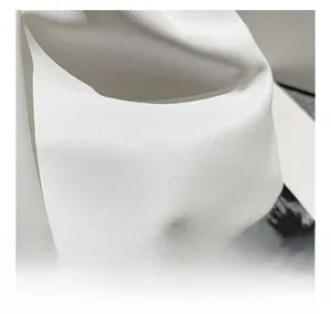 Dettaglio della trama in pelle bianca con motivo litchi e catena in metallo grigio