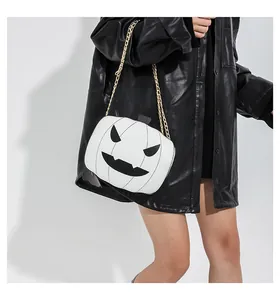 Λεπτομέρεια λευκής τσάντας κολοκύθας Halloween με μαύρο πρόσωπο και χρυσή αλυσίδα ώμου