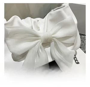 Dettaglio borsa bianca arricciata con grande fiocco in organza e catena in metallo