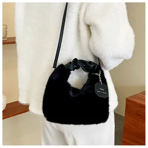 Détail du sac à main noir en fausse fourrure avec poignée froncée et bandoulière