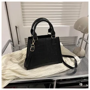Detalle del bolso negro con diseño de cocodrilo y herrajes dorados de alta calidad
