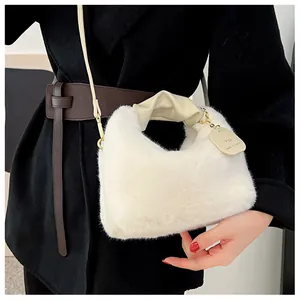 Détail du sac à main en fausse fourrure blanche avec poignée en cuir plissée et métal doré