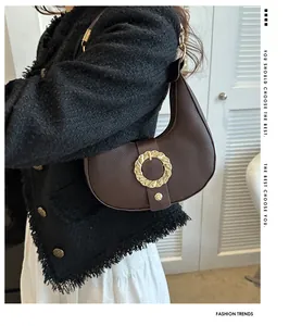 Detail of dark brown crescent underarm bag with lychee texture and gold buckle