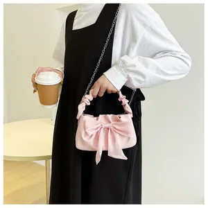 Borsa a mano rosa a pieghe con grande fiocco in tessuto e catena d'argento in stile vita