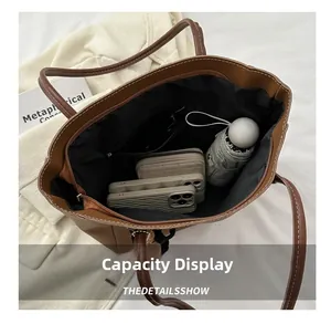 Detail showing spacious interior of brown tote bag with zipper pocket and essentials
