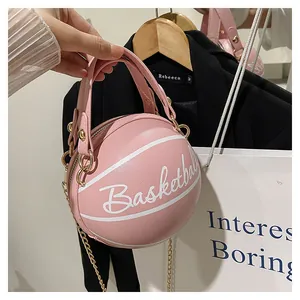 Détail d'un sac à main rose en forme de basket avec texture grainée et chaîne dorée