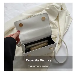 Top view of white faux crocodile leather handbag showing internal capacity for phone and wallet