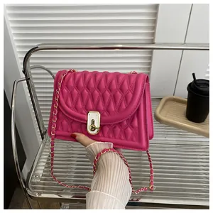 Close-up of fuchsia quilted crossbody bag with gold chain strap and metal turn-lock