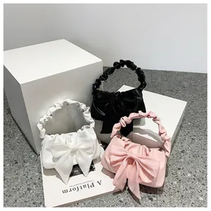 Tre borse a mano plissettate in bianco nero e rosa con grandi fiocchi in tulle dettaglio