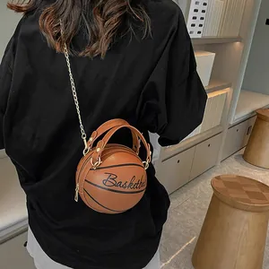 Sac bandoulière original en forme de basket marron avec chaîne dorée porté par un modèle
