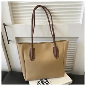 Detail of light khaki PU leather tote bag with slim dark brown shoulder straps