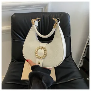 Detail of white crescent moon bag showing lychee pattern leather and gold hardware