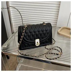 Close-up of diamond quilted texture and gold-tone twist lock on a black crossbody bag
