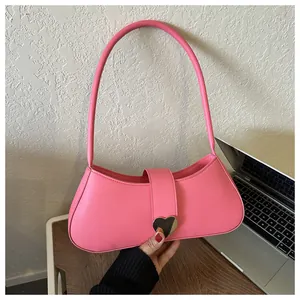 Detail of pink PU leather underarm bag featuring a large silver heart metal buckle