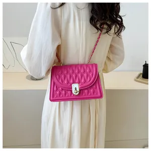 Close-up of a vibrant fuchsia quilted shoulder bag with elegant silver chain and metal lock