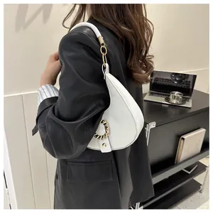 White crescent underarm bag with gold ring detail and textured lychee pattern leather